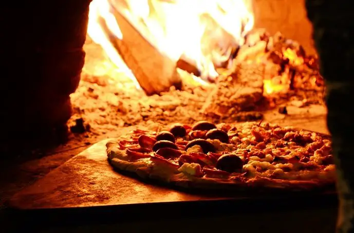 Pizza qui cuit dans un four à bois