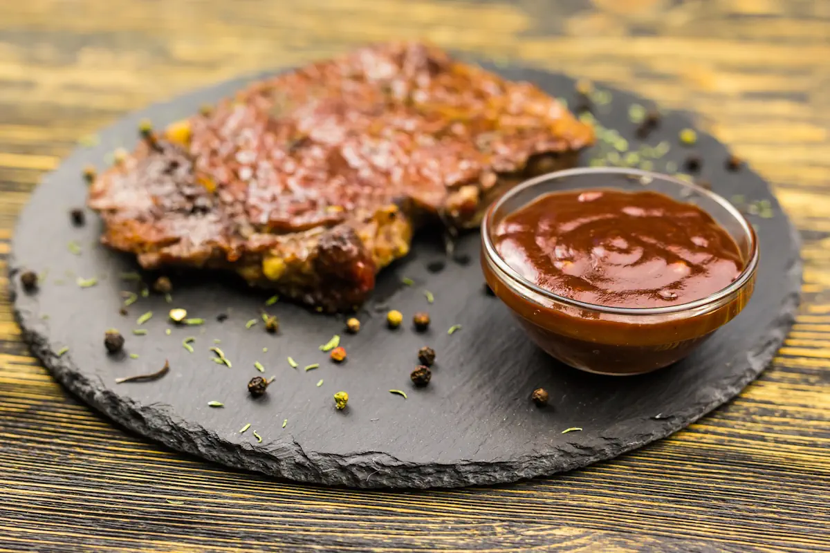 Une assiette de viande grillée accompagnée d'une sauce