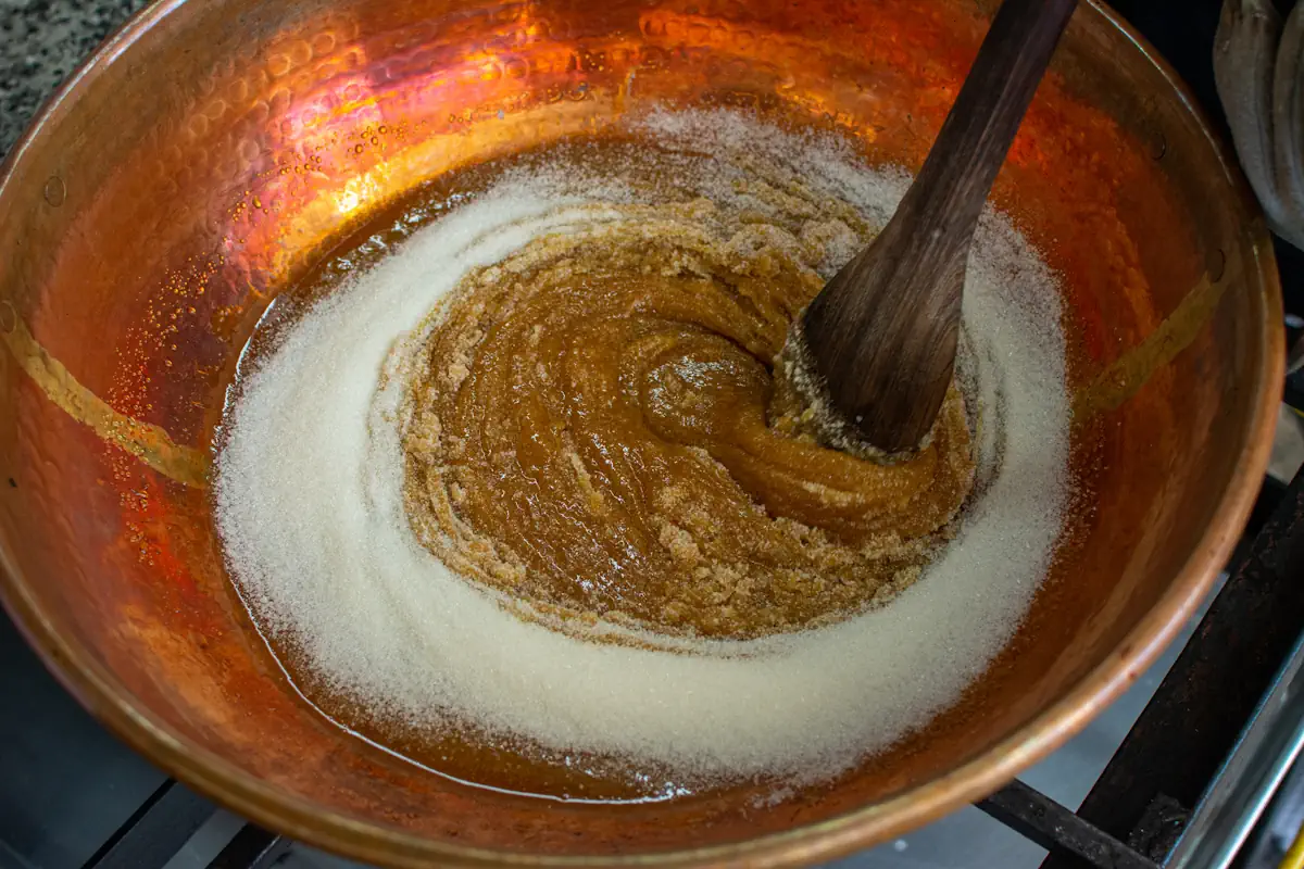 Une personne entrain de touiller du sucre blanc pour faire du caramel
