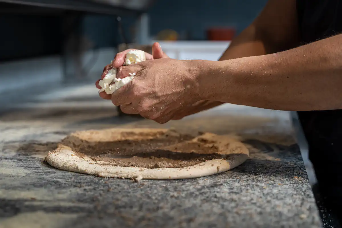 Une personne qui façonne une pâte pour faire de la pizza
