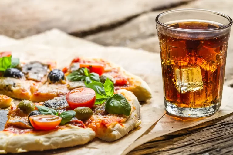 Une pizza avec un boisson posés sur une table