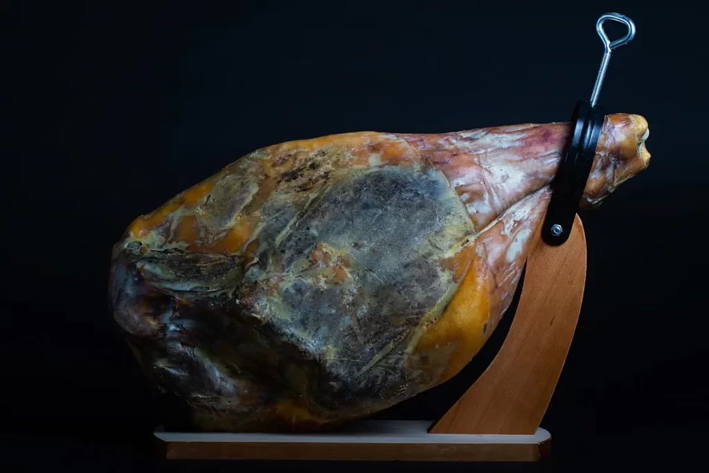 Un jambon en train de sécher sur un présentoir en bois