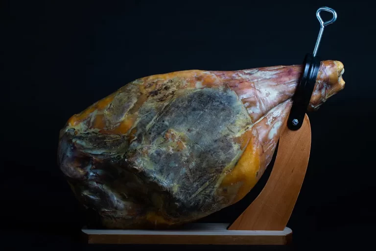 Un jambon en train de sécher sur un présentoir en bois