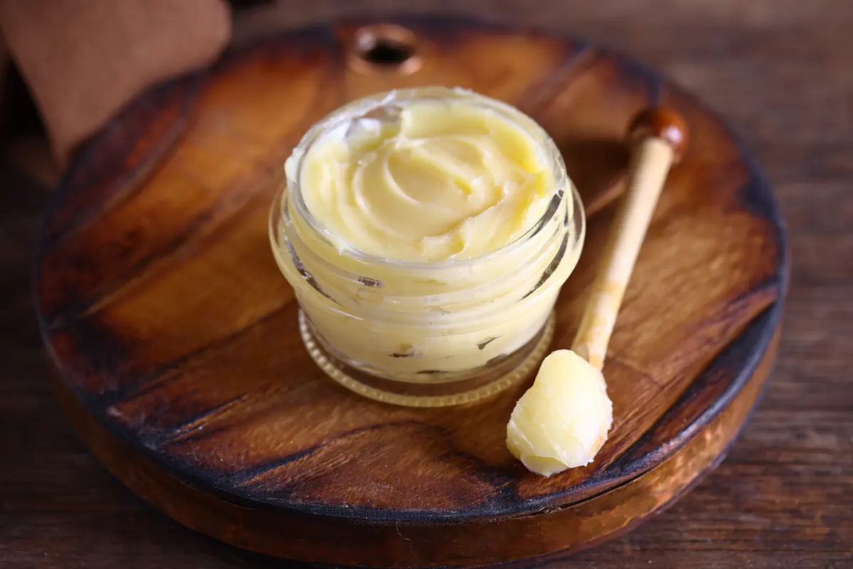 Un pot de mayonnaise posé sur un présentoir en bois à côté d'une cuillère en bois