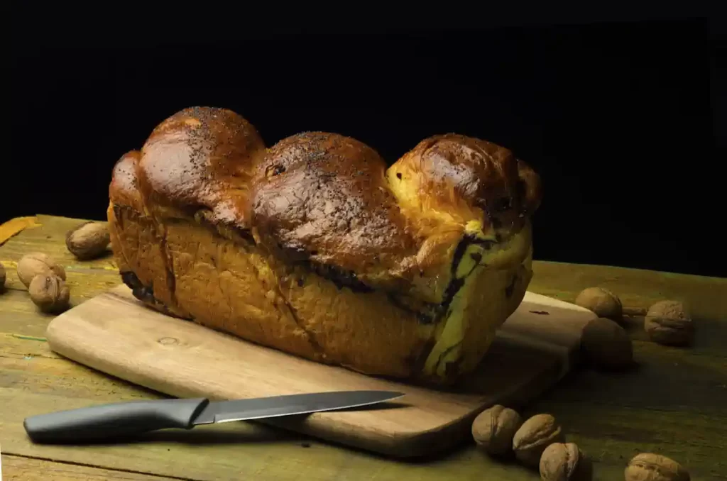 Une brioche sur une planche à découpé à côté d'un couteau