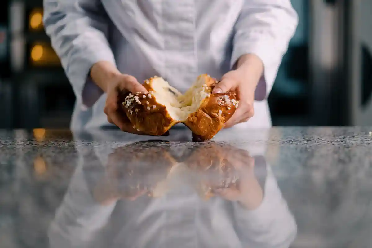 Une personne qui coupe une brioche en deux
