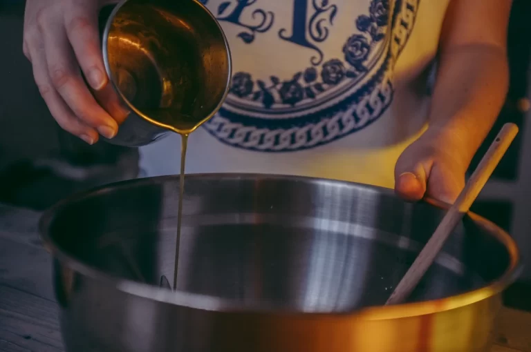 Une femme qui verse du sirop d'agave dans un bol en alu