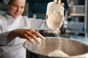 Une femme qui manipule de la farine