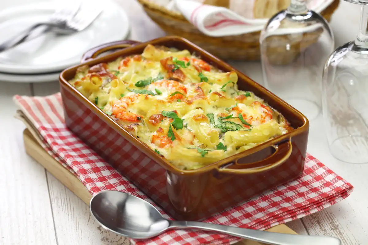 Tartiflette aux fruits de mer dans un plat posé sur une serviette rouge et blanc