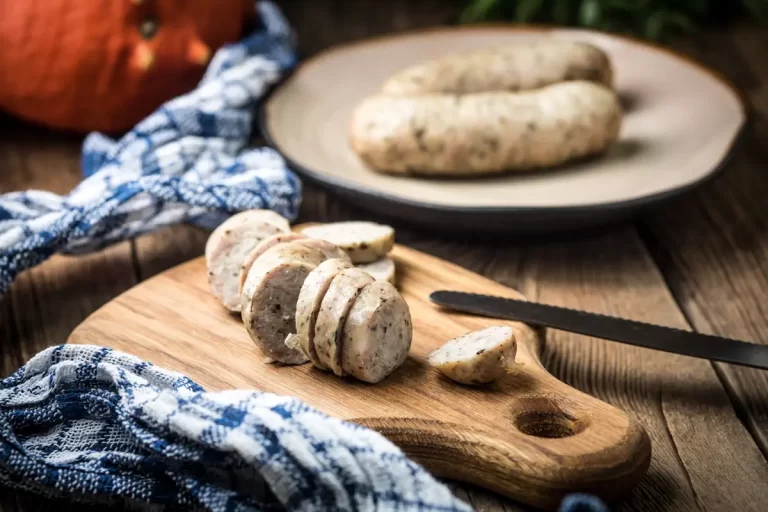 Des boudins blanc sur une assiette et une autre coupée en rondelle sur un présentoir en bois