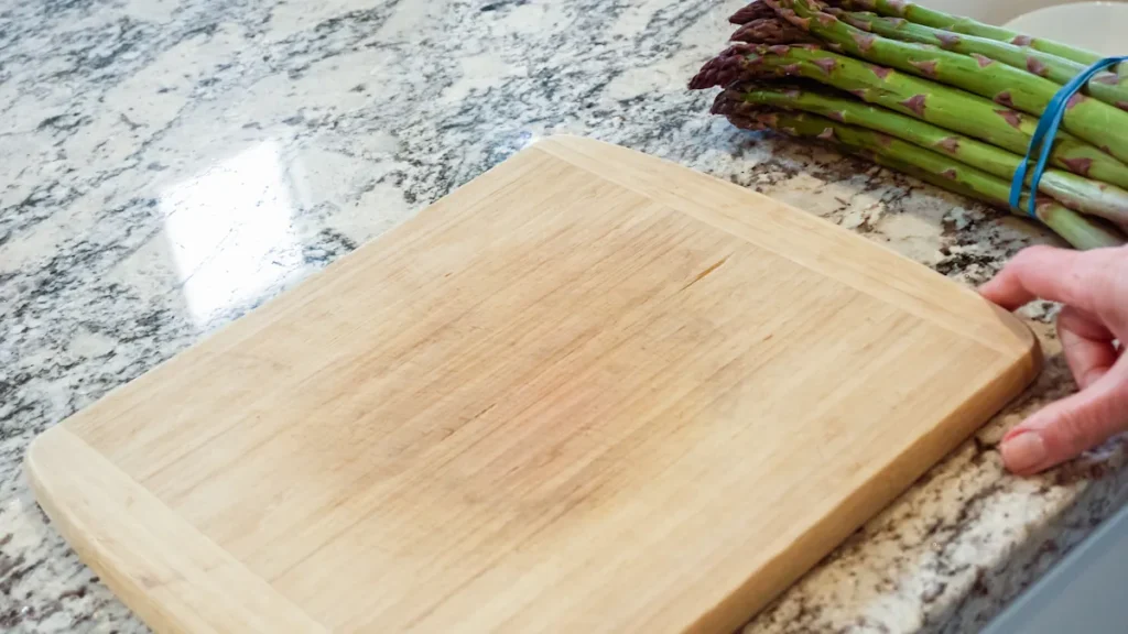 une personne qui pose une planche à découper sur une surface en pierre