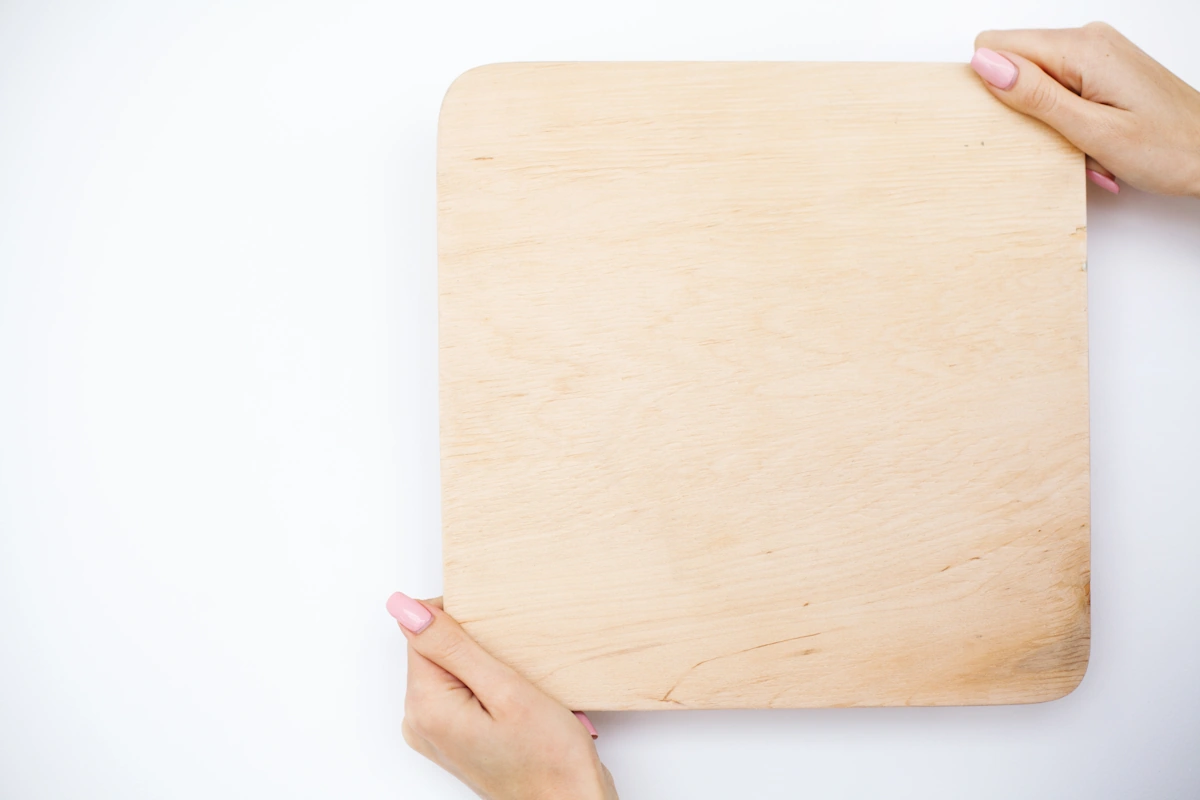 Une personne qui tient une planche à découper propre