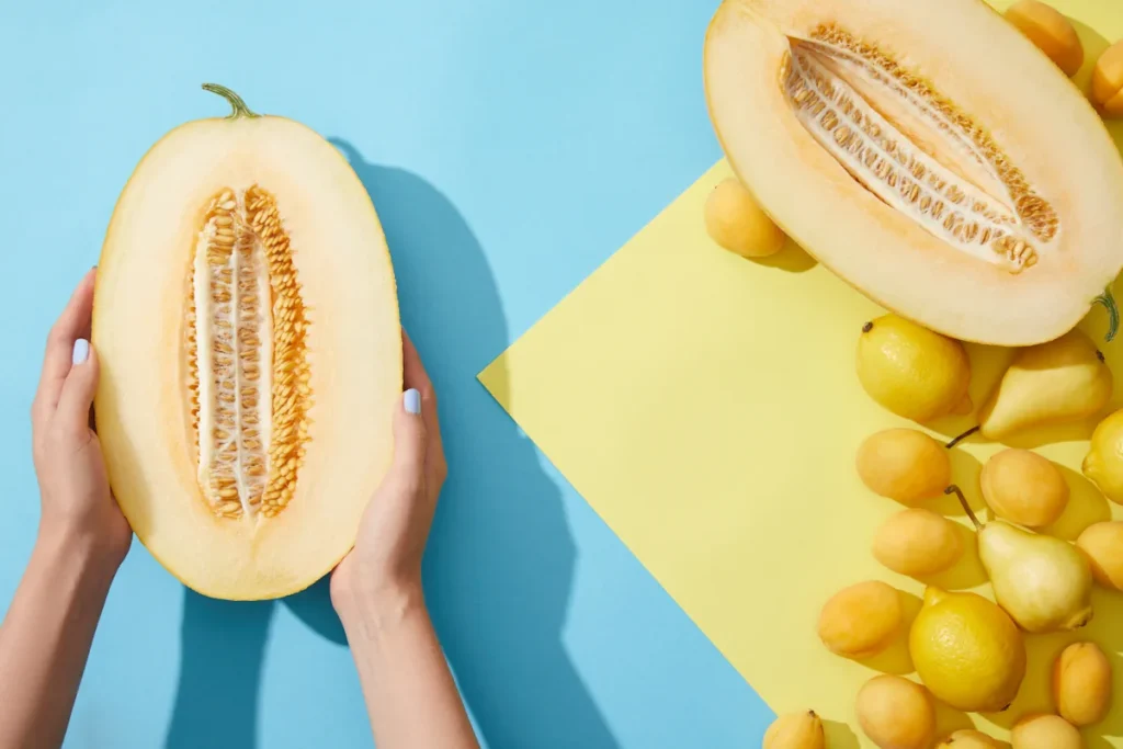 Une personne qui coupe un melon jaune