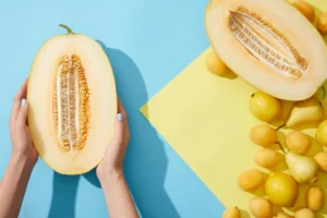 Une personne qui coupe un melon jaune