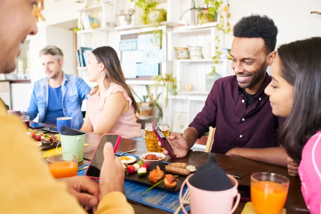 Des couples devant un brunch en regardant leur téléphone