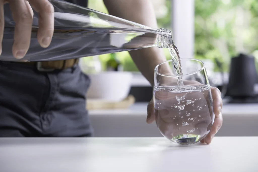 Une personne qui se sert un verre d'eau pétillante