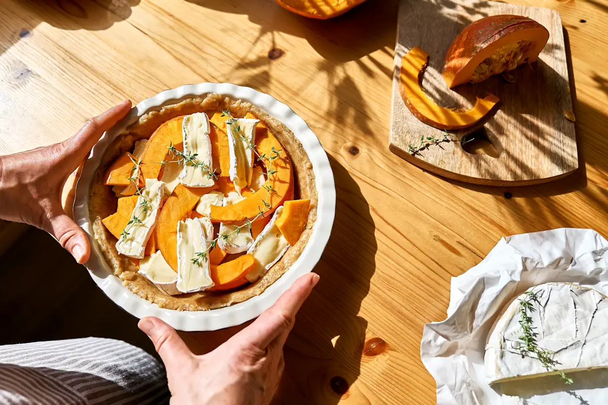 Quelqu'un qui prépare un plat de courge avec du fromage