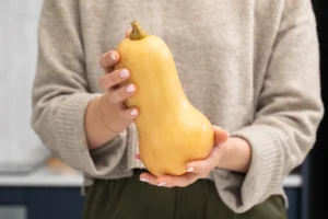 Une personne qui tient un butternut