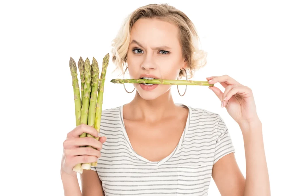 Une femme qui mange des asperges