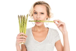 Une femme qui mange des asperges